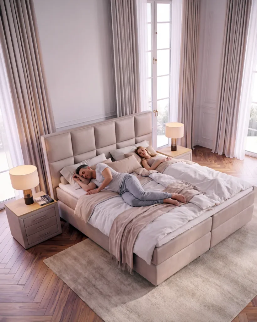 Zwei Erwachsene in einem breiten Boxspringbett mit viel Bewegungsfreiheit und Abstand zueinander